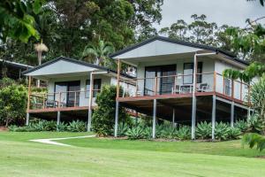 a house with balconies and a yard at Sunshine Coast retreat your own private golf course in Diddillibah