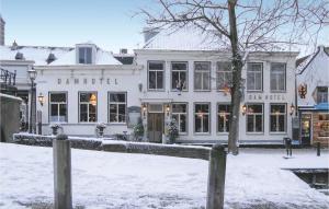 a white building with a fence in the snow at Het Edamse Vissershuisje in Edam