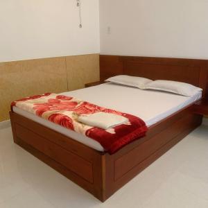 um quarto com uma cama grande e uma estrutura em madeira em Hotel Thanh Minh em Châu Làng Chánh