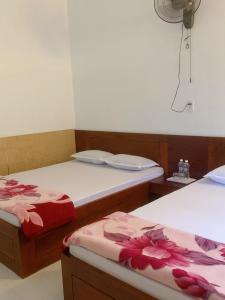 Châu Làng ChánhにあるHotel Thanh Minhの花が飾られたベッド2台が備わる客室です。