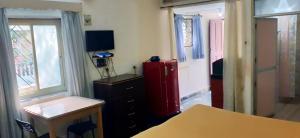 Zimmer mit einem roten Kühlschrank und einem Fenster in der Unterkunft Alexmarie Guest house 5 min to candolim Beach in Aguada