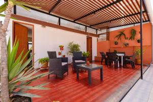 Charming Miraflores Guesthouse with Terrace Studio Apartment and Private Room في ليما: فناء به طاولات وكراسي في مبنى