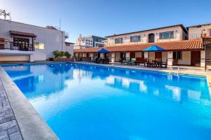 エンセナダにあるHotel Casa del Solの建物の前に青い水を使用した大型スイミングプール