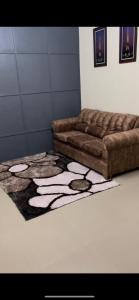 una sala de estar con un sofá marrón sobre una alfombra en Hagley Park Villa, 