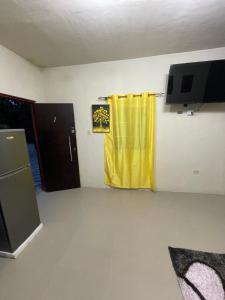 a room with a yellow curtain and a tv at Hagley Park Villa 
