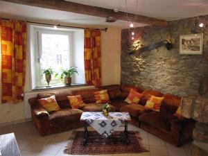 Les Bucherons في افينه: غرفة معيشة مع أريكة جلدية وطاولة