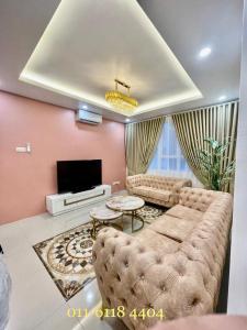 ein Wohnzimmer mit einem Sofa und einem TV in der Unterkunft Alaghapoo Service Apartment Near Drawbridge in Kuala Terengganu