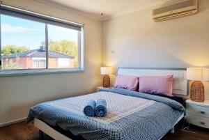 um quarto com uma cama com duas toalhas azuis em Rosie House-Spacious comfortable Home em Melbourne