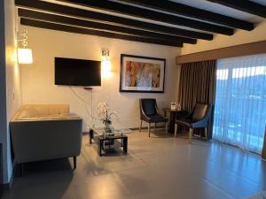 uma sala de estar com um sofá e uma televisão em Hotel Casa del Sol em Ensenada