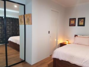 a bedroom with two beds and a mirror at Pemberton Japanese Garden Studio in Pemberton