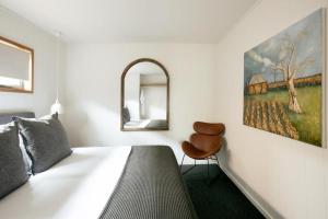 Un dormitorio con una cama y un cuadro en la pared. en Cupitt's Estate Villas, en Ulladulla