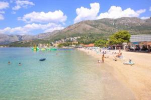 a beach with a bunch of people in the water at Apartment Antea - private parking in Čilipi