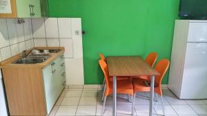 een kleine keuken met een tafel en een wastafel bij Apartments Mat - 100 m from sea in Srima