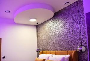 ein lila Zimmer mit einem Sofa und einer lila Wand in der Unterkunft Apartment Turbo - with terrace, AC & WiFi in Zaprešić