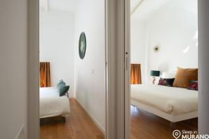 a bedroom with two beds and a mirror at MURANO Place - FILIGRANA House in Murano