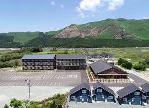 une vue aérienne sur un hôtel avec des montagnes en arrière-plan dans l'établissement Aso Hakuun Sanso, à Aso