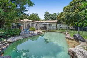 una piscina frente a una casa en Belle Escapes Under the Mango Tree Holiday Home en Trinity Beach