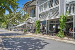 une rue vide en face d'un bâtiment avec des tables et des chaises dans l'établissement Belle Escapes Under the Mango Tree Holiday Home, à Trinity Beach