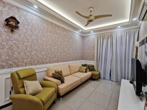 a living room with a couch and two chairs at English Homestay Seaview Johor Bahru Permas 6 pax in Masai