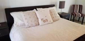 a bedroom with a bed with white sheets and pillows at Maison de Chocolate in Broken Hill