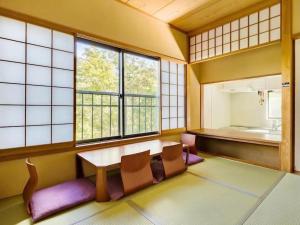 a room with a table and chairs and windows at 雅・小涌谷　温泉別荘　Miyabi Kowakudani Hopspring Villa in Ashinoyu