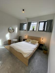 a bedroom with a large bed in a room with windows at YASI Hostel in Lyon