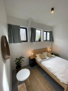 une chambre avec un lit et une table et deux fenêtres dans l'établissement YASI Hostel, à Lyon