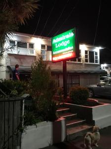 a sign in front of a house with a dog in front at Admirals Lodge in Picton