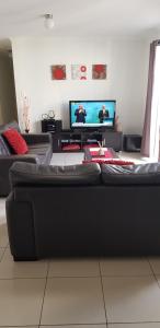 a living room with a couch and a flat screen tv at Maison de Chocolate in Broken Hill