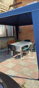 a table and chairs under a blue umbrella at Holiday Home at Fedkovycha St. in Kyiv