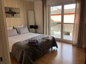 1 dormitorio con cama y ventana grande en Appartement l'œil de Colmar, en Colmar