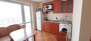 a kitchen with a table and a white refrigerator at Apartment on Patriarkha Mstyslava Skrypnyka Street in Kyiv