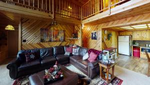 una sala de estar con un sofá de cuero en una cabaña en Standing Bear Lodge With High Speed Wifi, en Red River