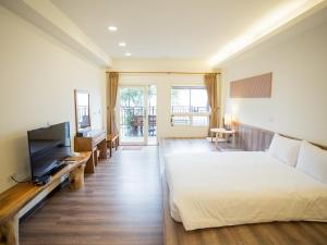 een slaapkamer met een bed en een flatscreen-tv bij Cloud Villa in Hualing