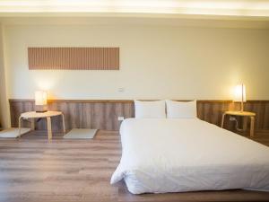 a bedroom with a large white bed and two tables at Cloud Villa in Hualing