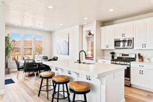 una cocina con armarios blancos y una isla de cocina con taburetes en Paseos Poolhouse home, en Washington