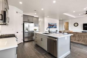 una cucina con mobili bianchi e un frigorifero in acciaio inossidabile di Pool View at Paseos townhouse a Washington