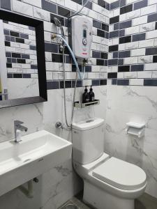 a bathroom with a shower and a toilet and a sink at A ONE Holiday Apartment in Tanah Rata