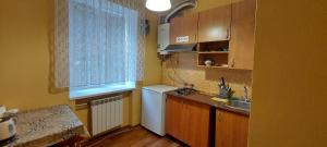 La cuisine est équipée d'un réfrigérateur blanc et d'un évier. dans l'établissement Воздухофлотский проспект, à Kiev