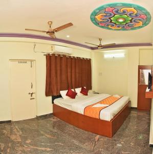 a bedroom with a bed and a ceiling at Ruthran Guest House in Mahabalipuram