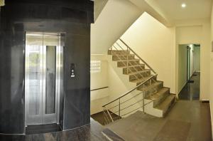 - un escalier dans un immeuble avec ascenseur en métal dans l'établissement Ruthran Guest House, à Mahabalipuram