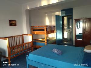 een slaapkamer met een blauw bed en een stapelbed bij La Terrasse in Rodrigues Island