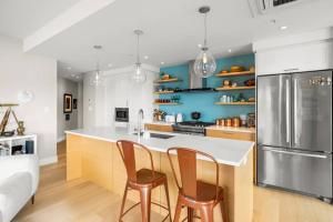 a kitchen with two chairs and a counter with a refrigerator at Waterfront - Serene Beauty of Sooke in Sooke