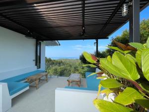 a patio with awning and a bench and trees at Villa Nour - 3 BR sea view pool villa in Srithanu in Srithanu