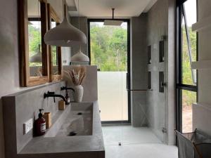 een badkamer met een wastafel, een spiegel en een douche bij Villa Nour - 3 BR sea view pool villa in Srithanu in Srithanu