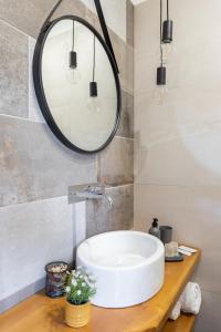 uma casa de banho com um lavatório branco e um espelho. em Old Rooms em Quartu SantʼElena