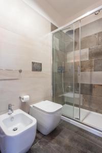 a bathroom with a toilet and a shower and a sink at Old Rooms in Quartu SantʼElena