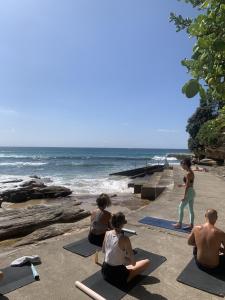 a group of people doing yoga on the beach at The Village Bondi Beach in Sydney