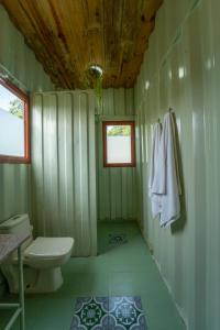 a green bathroom with a toilet and a window at Tree of Life Ecotainers Agra in Agra