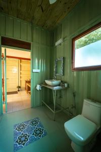 a green bathroom with a sink and a toilet at Tree of Life Ecotainers Agra in Agra